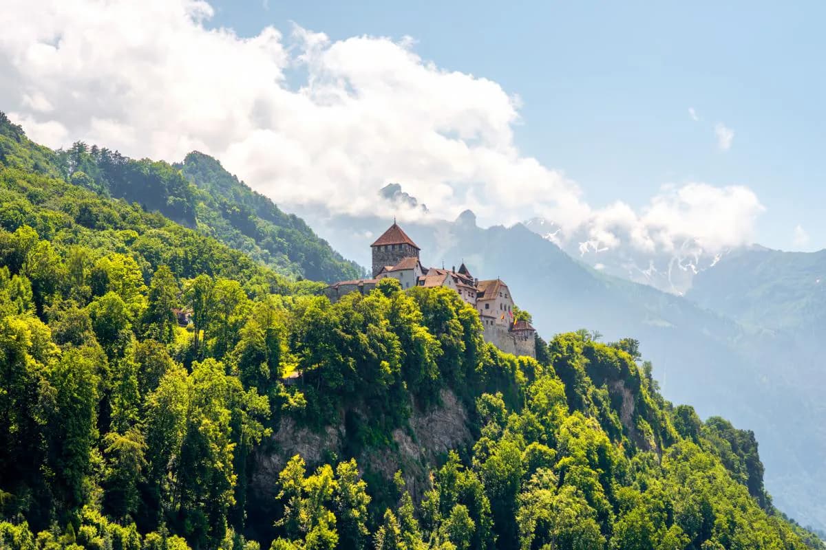 A mountain panorama with the castle of Vaduz in the capital of Liechtenstein on a sunny day.